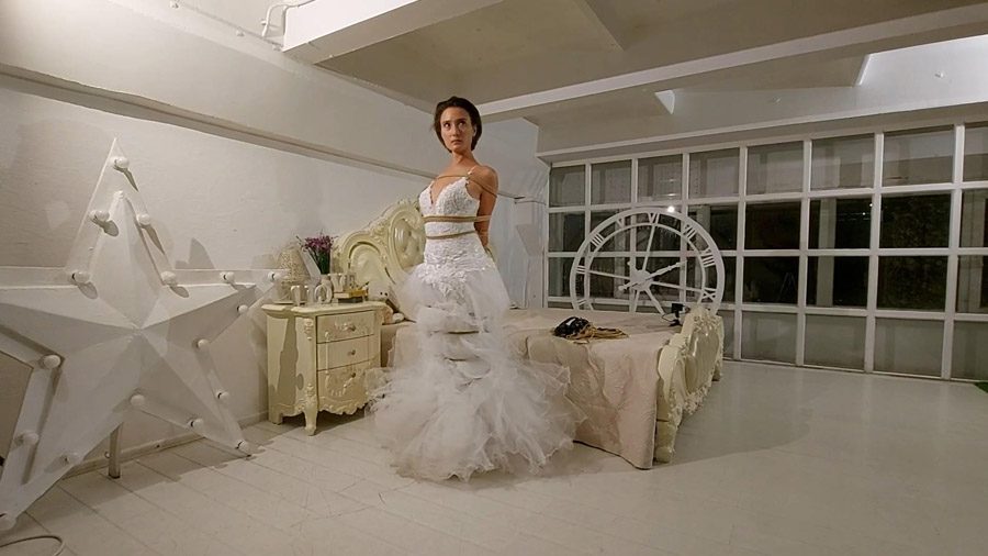Sofi tied up with ropes in wedding dress